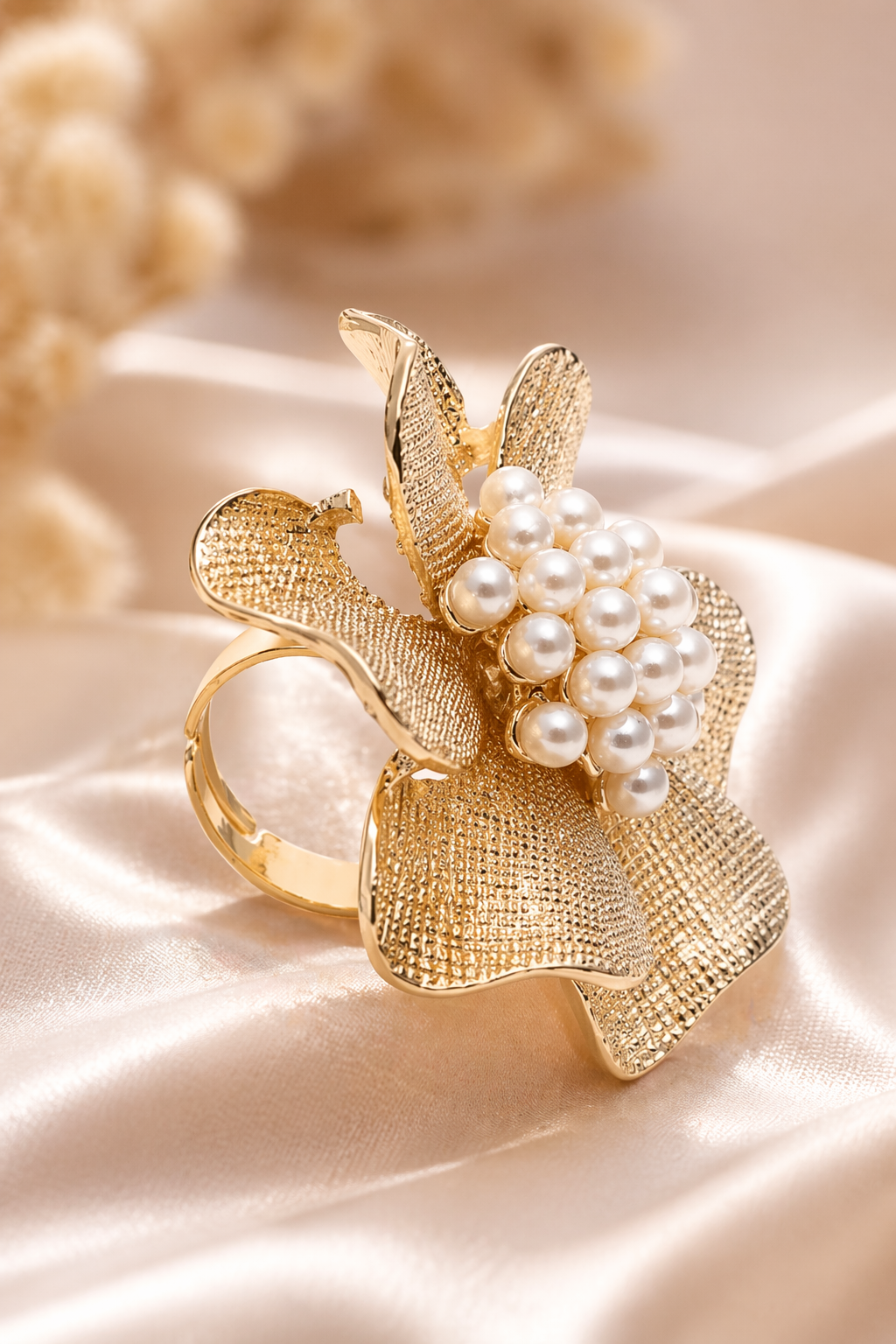 Gold ring with pearl embellishments on a soft beige background