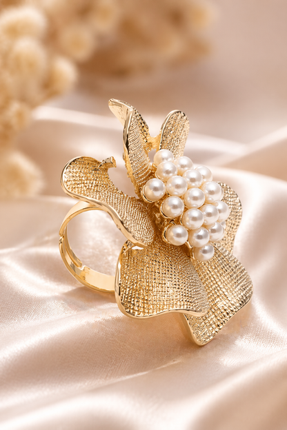 Gold ring with pearl embellishments on a soft beige background