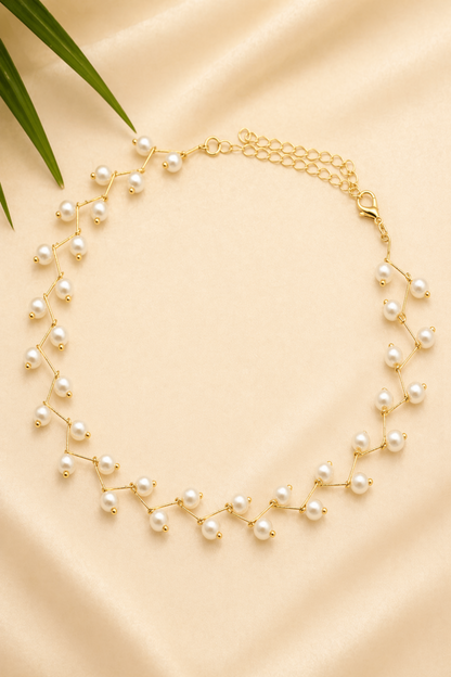gold pearl necklace on beige background
