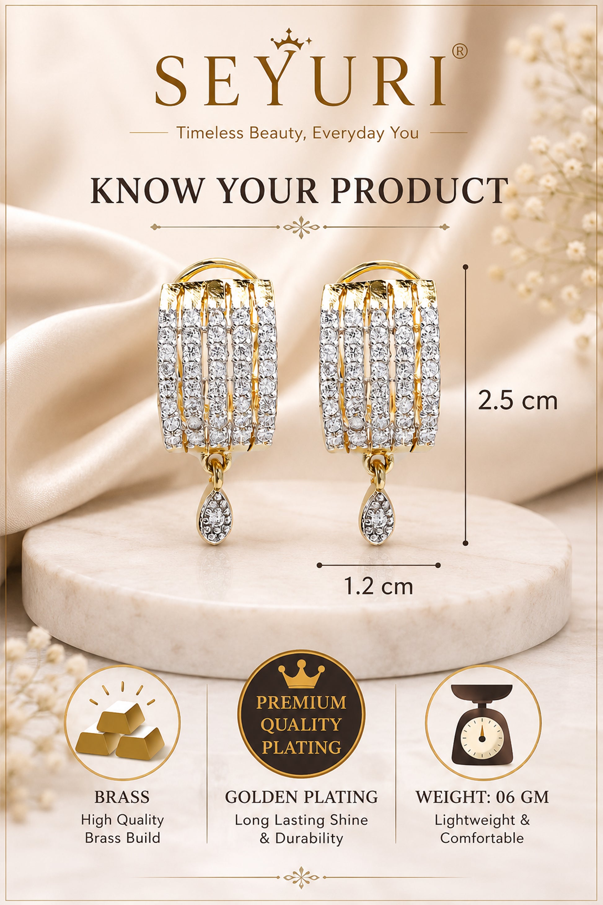 Gold plated earrings displayed on satin background