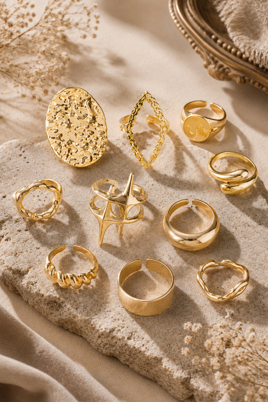 Gold statement ring set arranged on cream stone with vintage-inspired styling