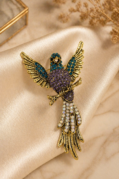 multicolor stone bird pin on satin fabric background