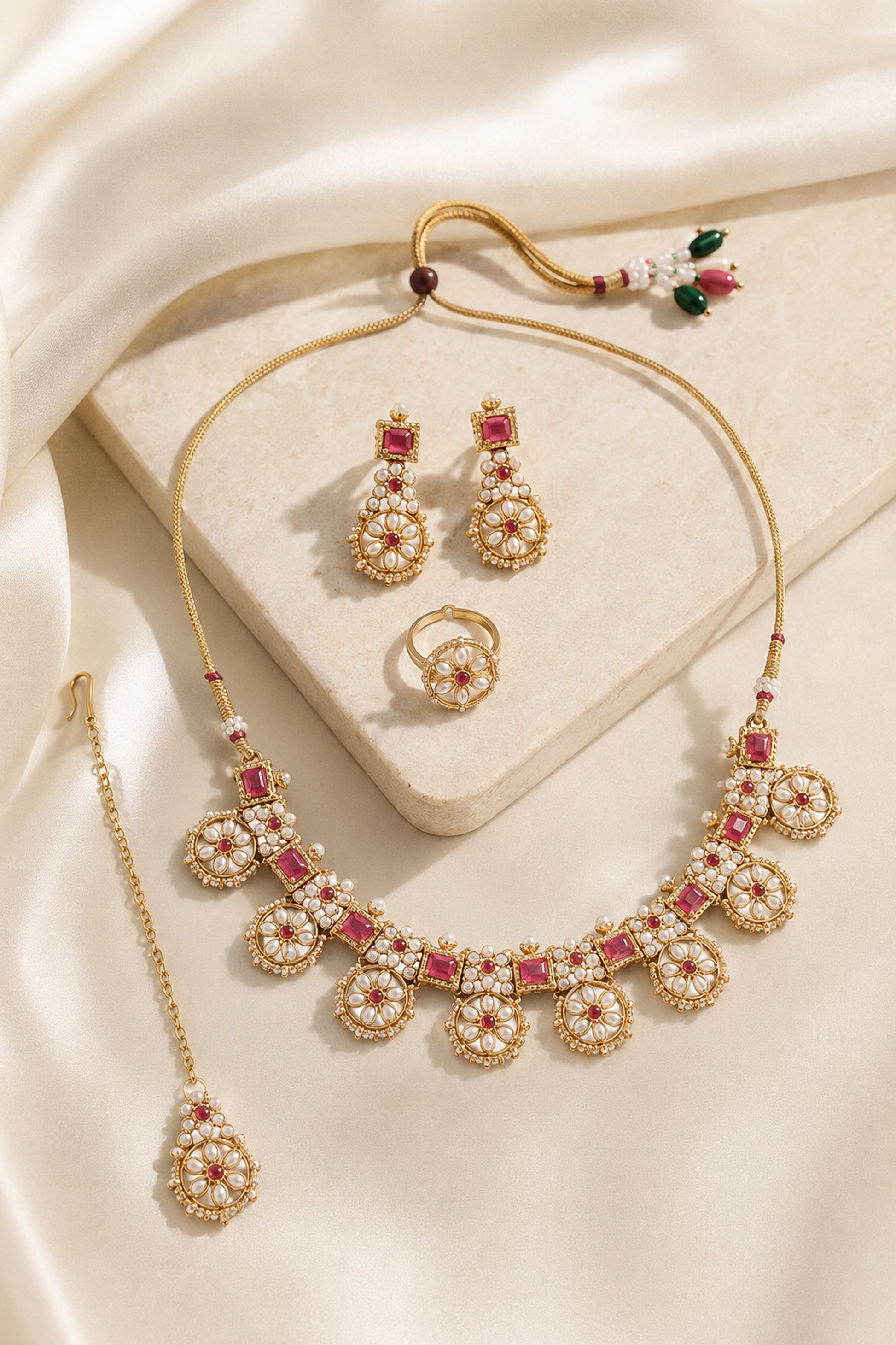 Gold tone jewelry set with red stones, white floral drops and matching earrings
