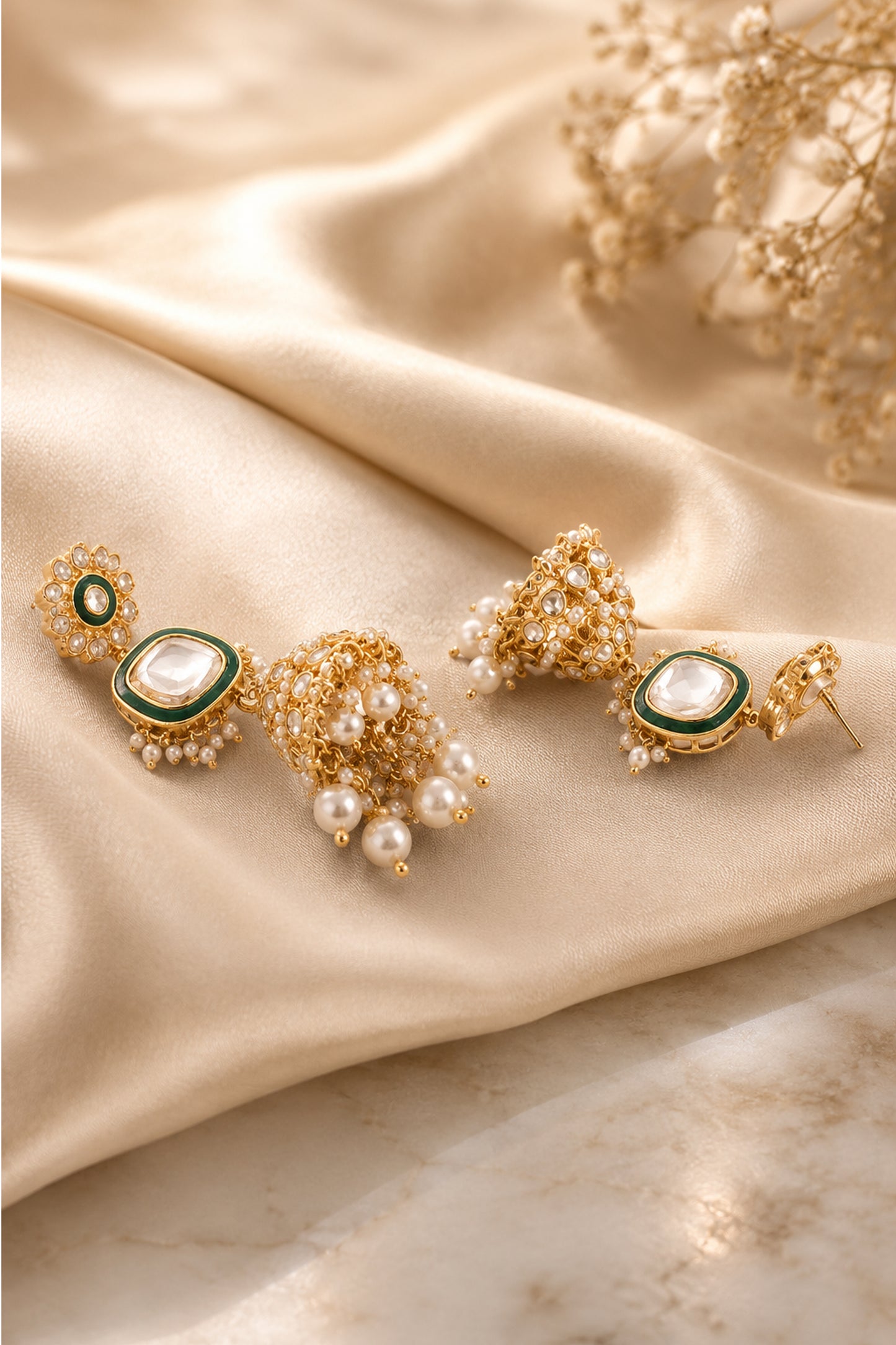 Front view of layered dome earrings with floral tops, dark green borders and clear stone detailing.