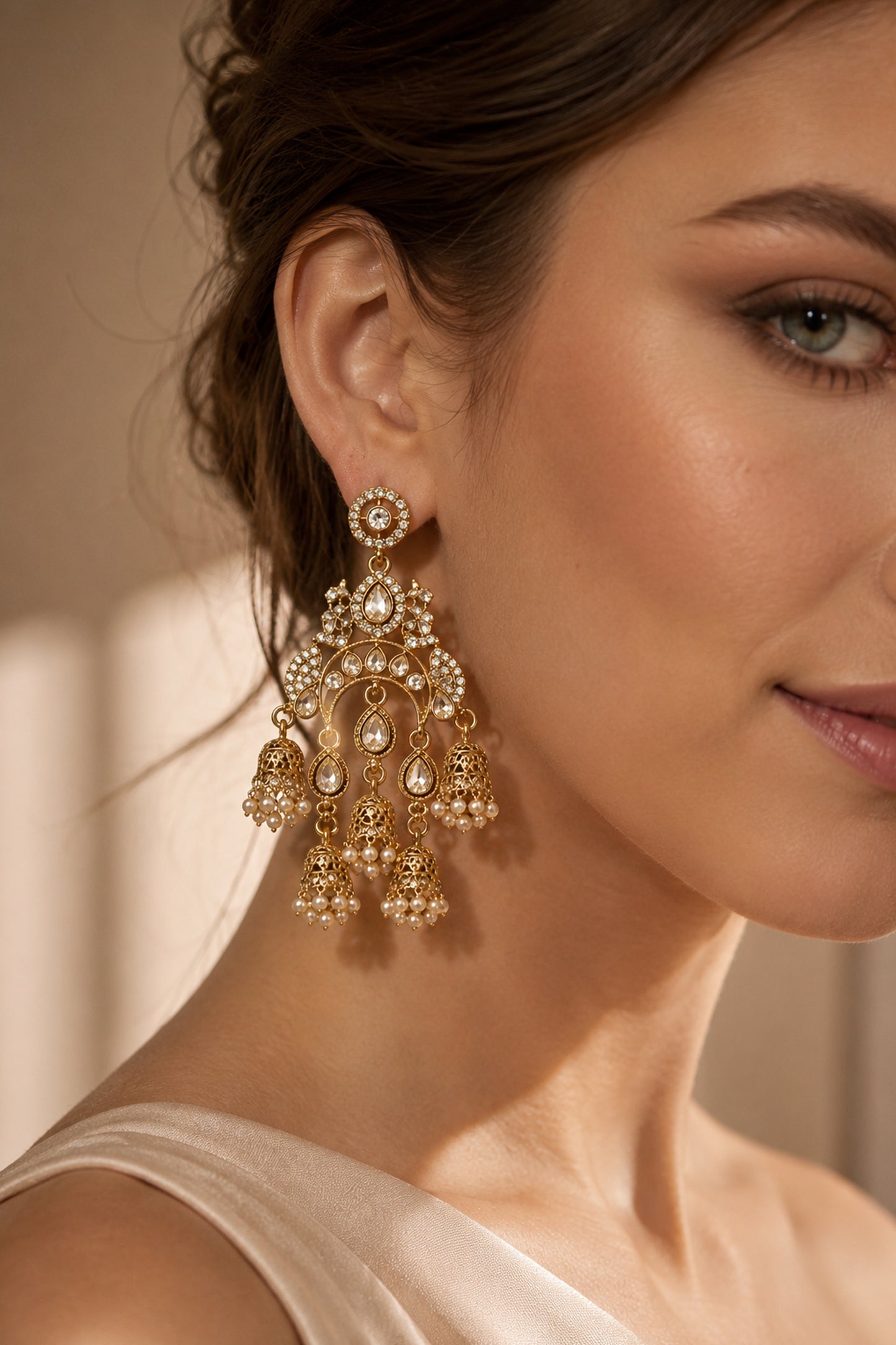 Close-up of polished gold-tone drop earrings with clear stones