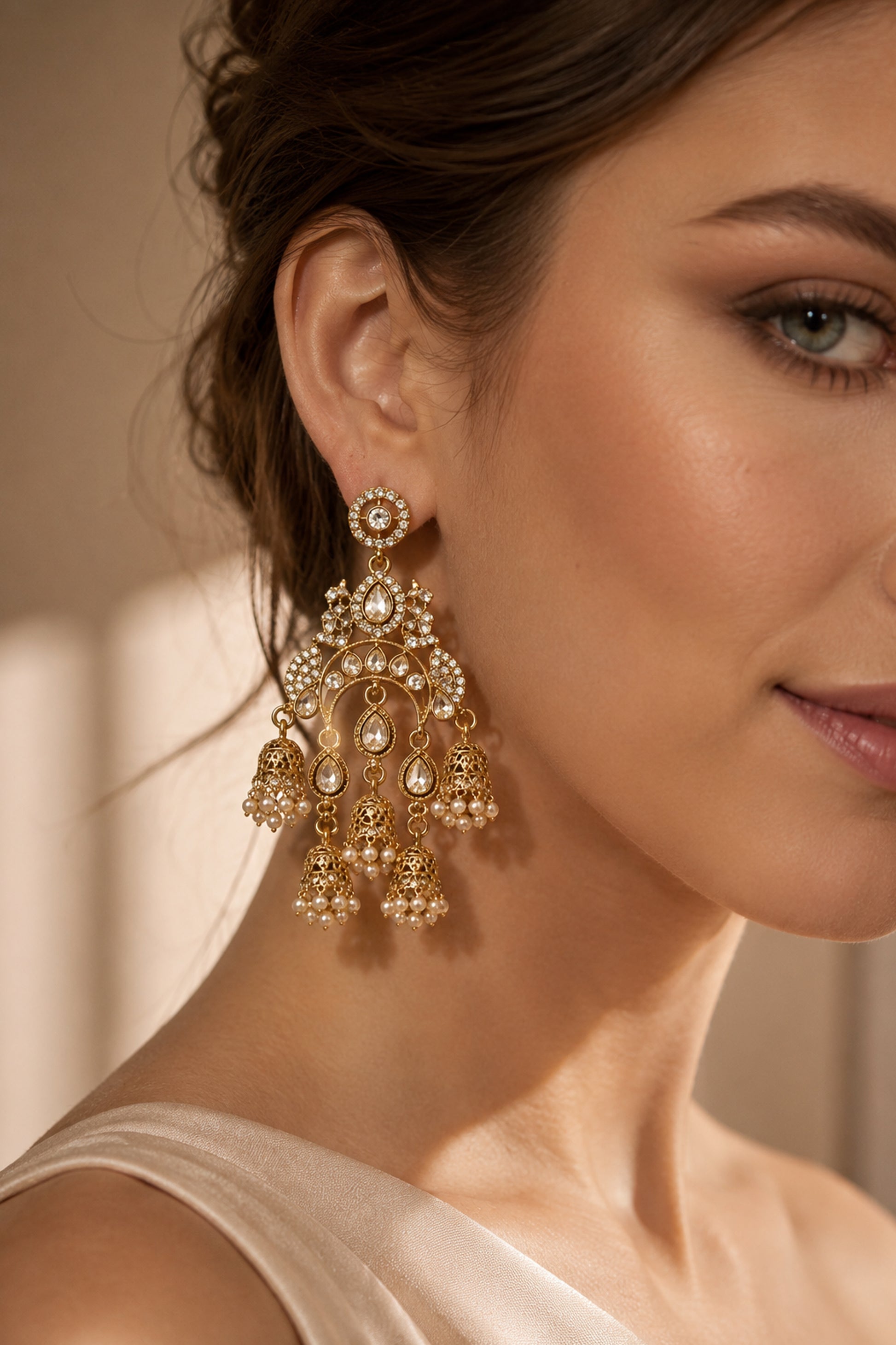 Close-up of polished gold-tone drop earrings with clear stones