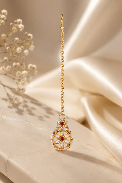 Close-up of gold-tone necklace with rectangular red stones and circular floral medallions