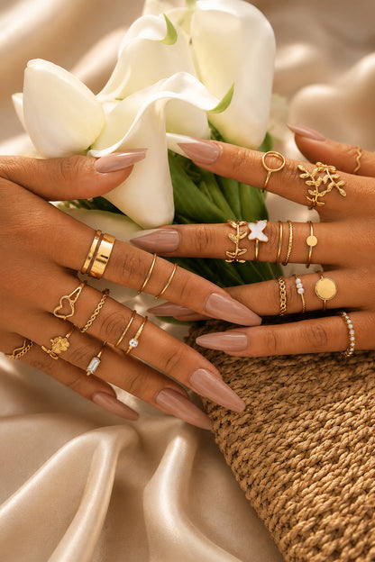 Knuckle rings layered across both hands with mixed gold-tone profiles