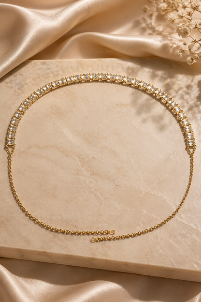 slim gold chain belt laid on beige surface