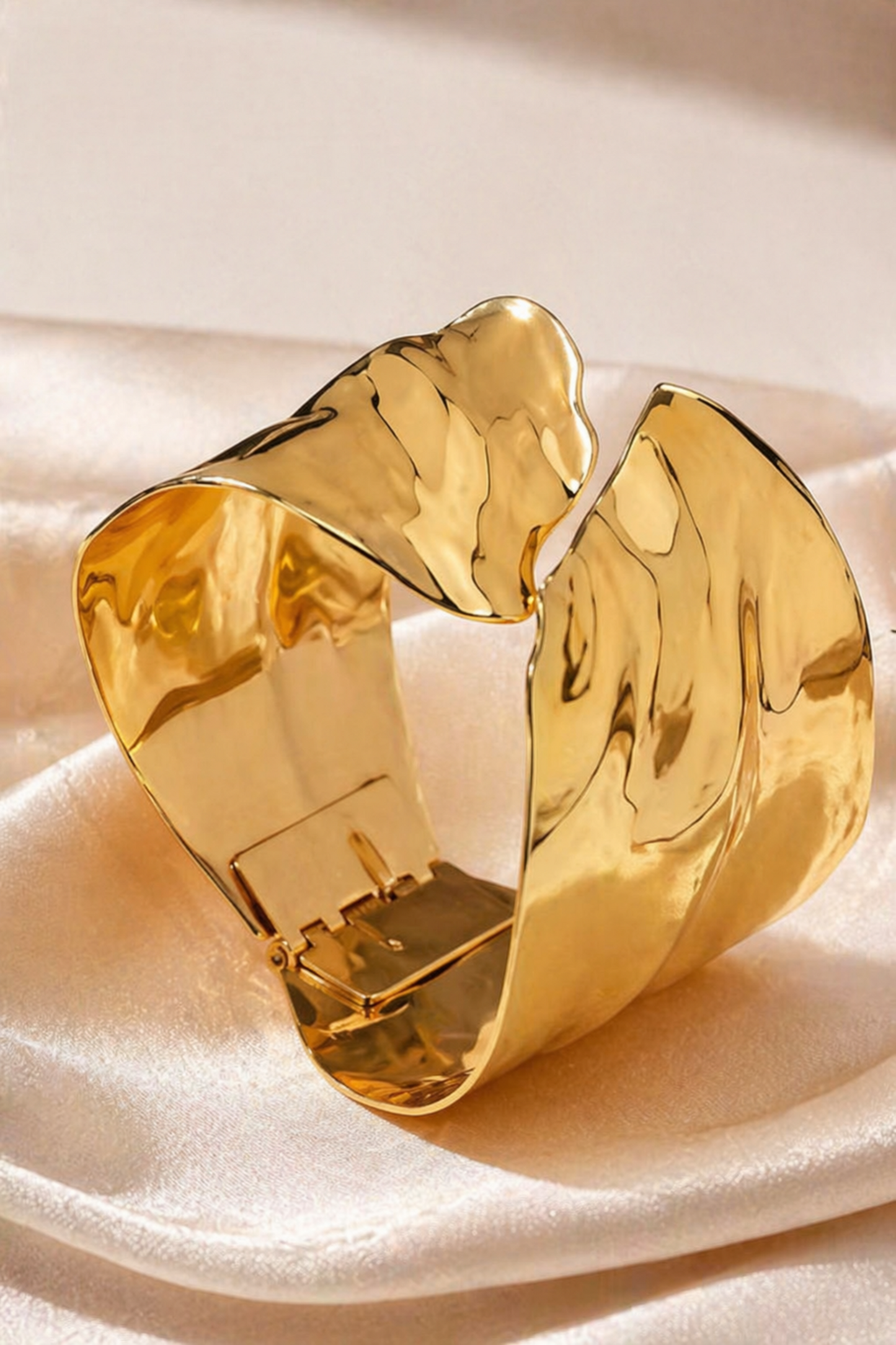 wide gold tone cuff bracelet on wrist