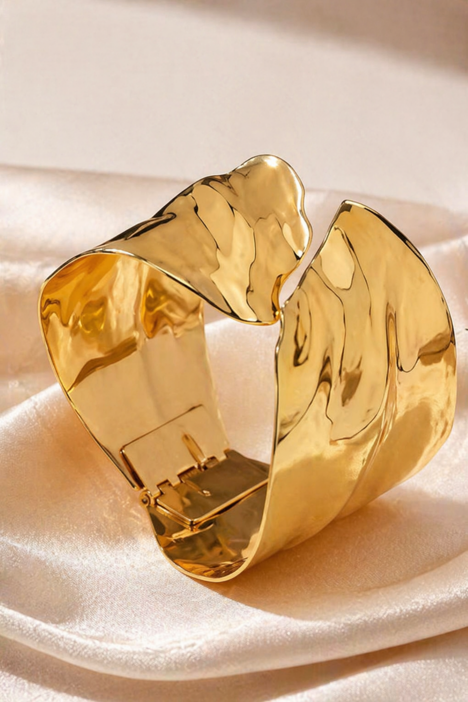 wide gold tone cuff bracelet on wrist