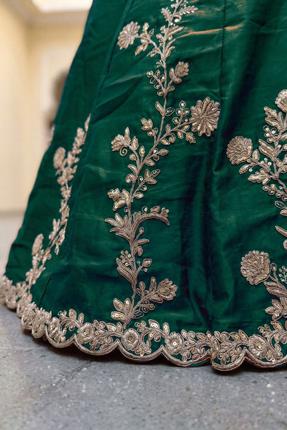 Close-up view of green Rangoli Silk fabric and embroidery