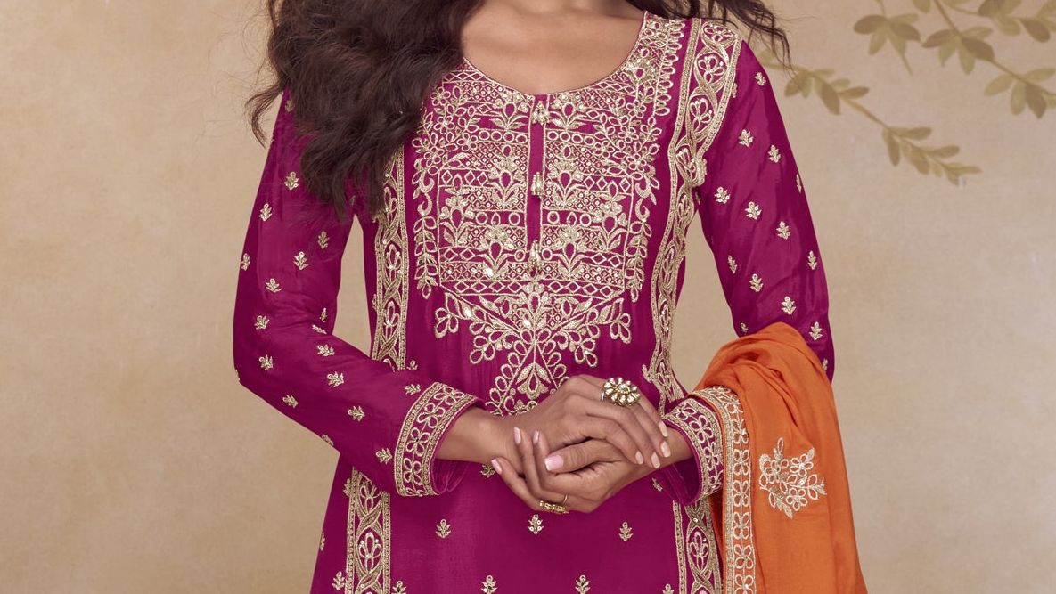 Close up embroidery hand work on magenta orange kameez design