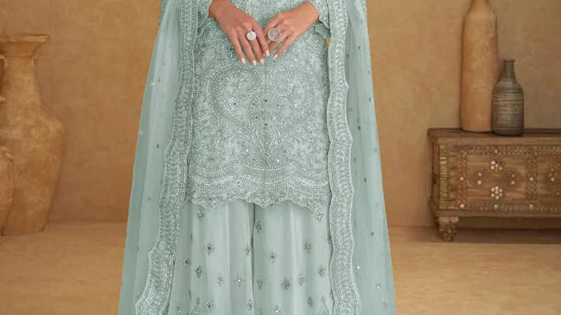 Embroidery craftsmanship close-up on mint blue net fabric