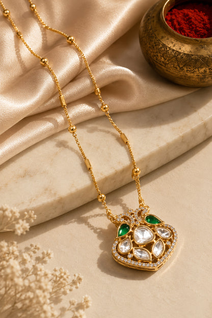 Rounded pendant with green teardrop and clear stones