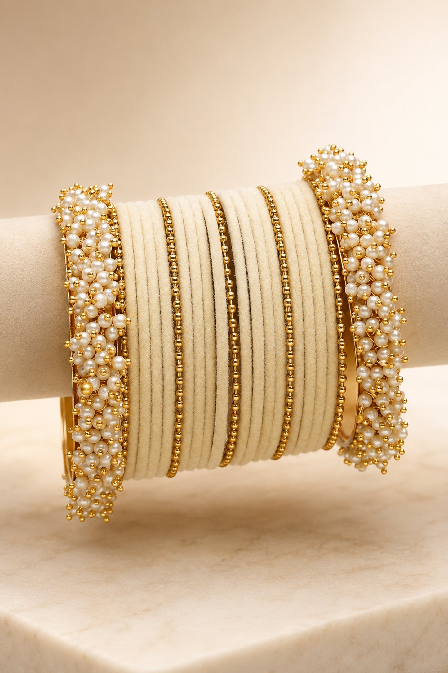 Close-up of white pearl-like bead clusters on wide bangles