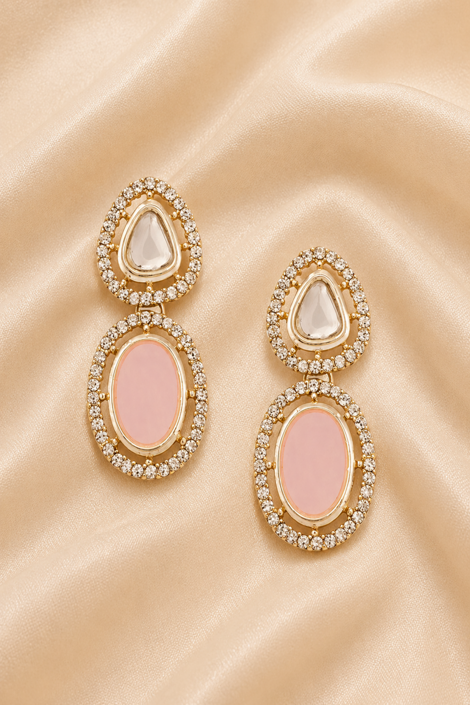Pink and reflective stone jewelry arranged on cream satin