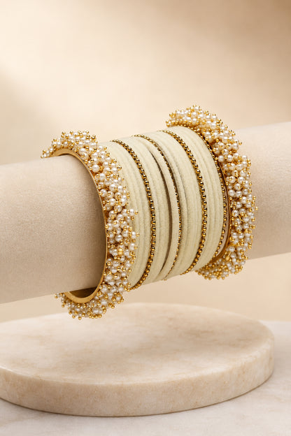 Ivory and gold-tone bangles displayed on cream marble