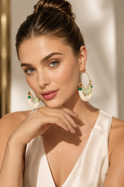 Model wearing layered white bead hoop earrings with swept-back hair