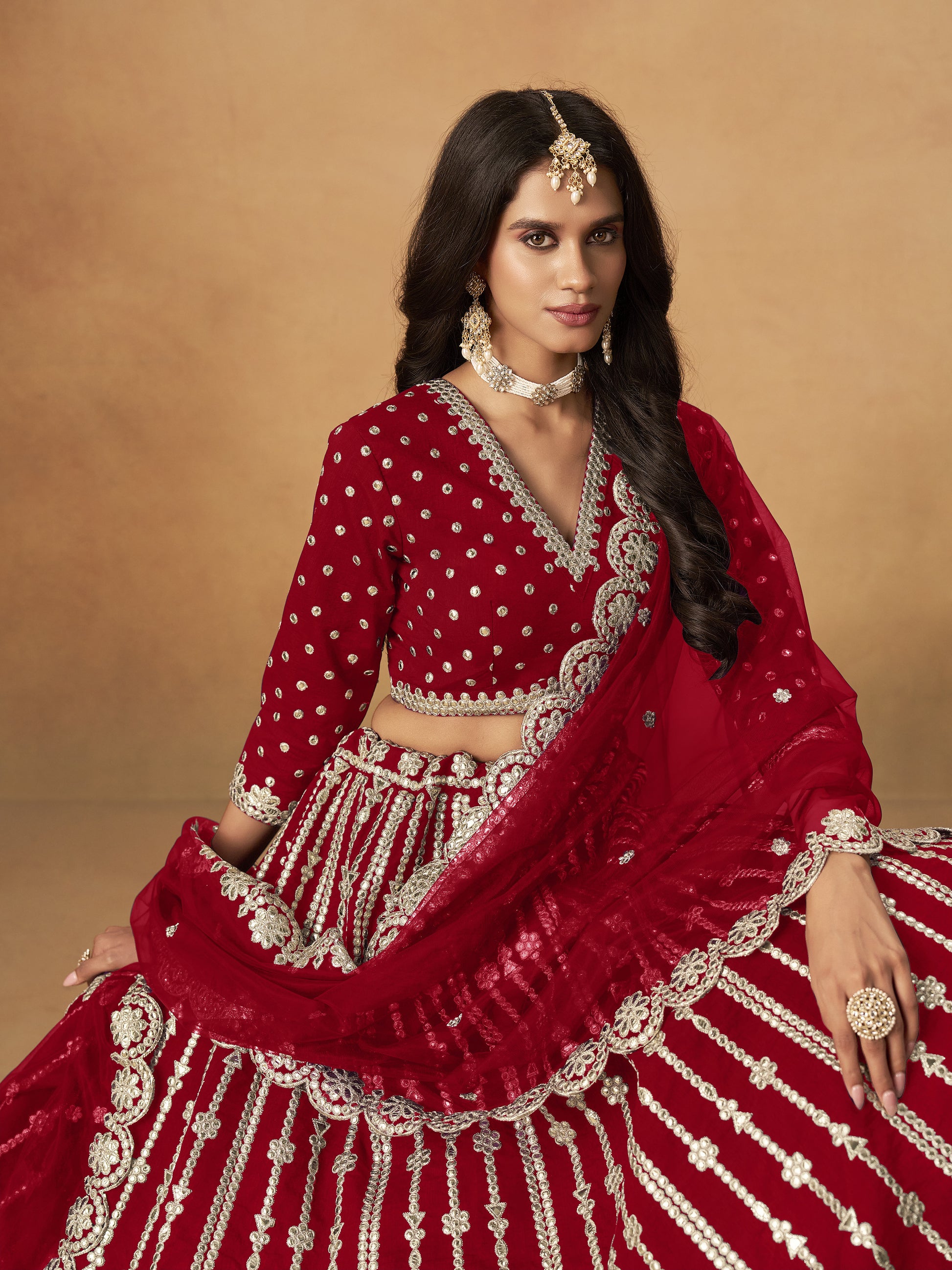 Close-up of heavy embroidery work on dark red lehenga fabric