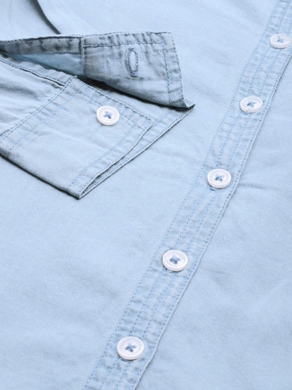 Fabric drape detail of cyan blue cotton shirt