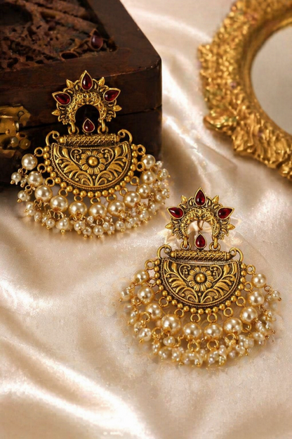 gold pearl chandbali earrings on silk background

