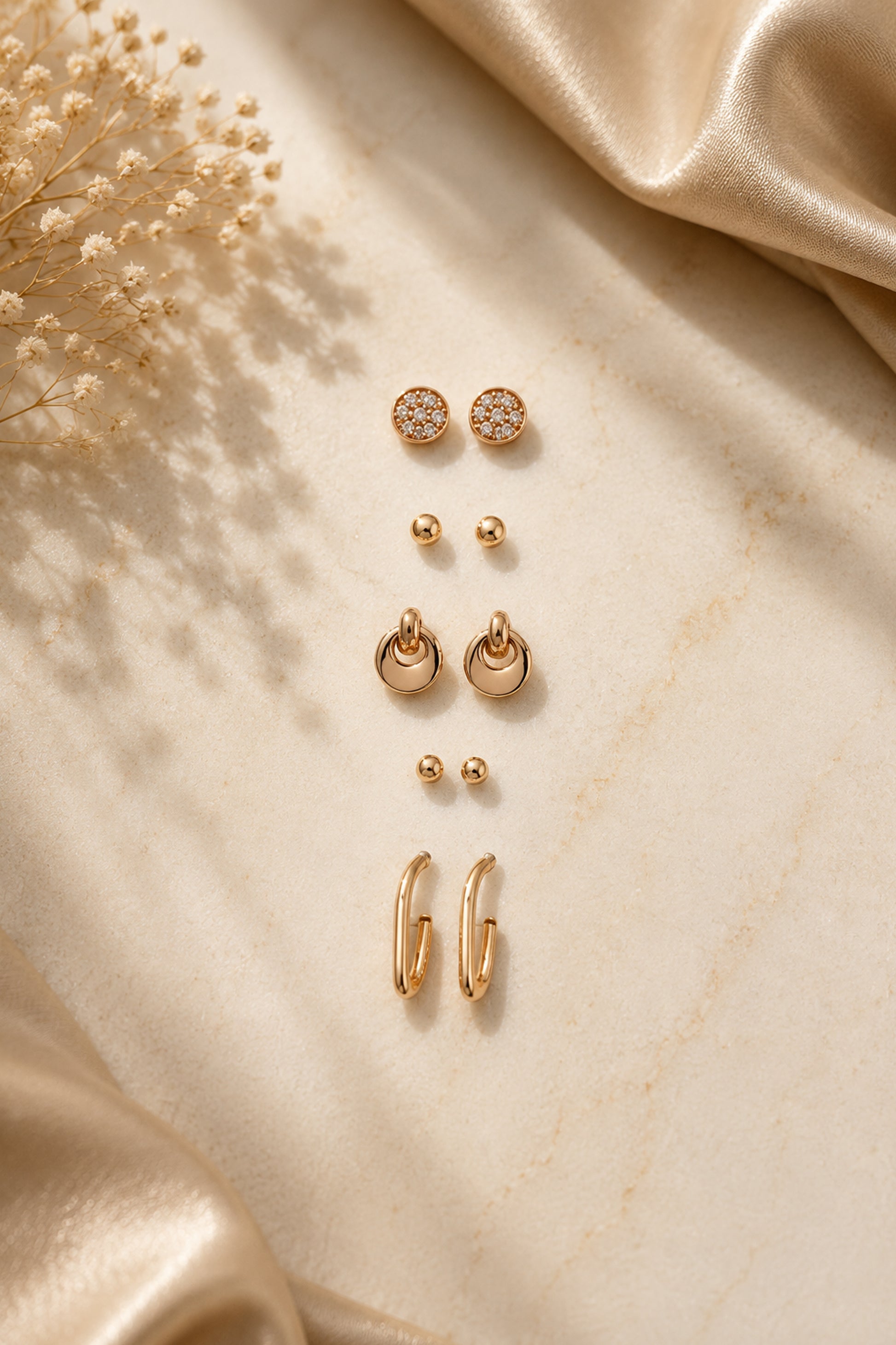 Mixed stud earrings with clear stones, pink accents and polished forms