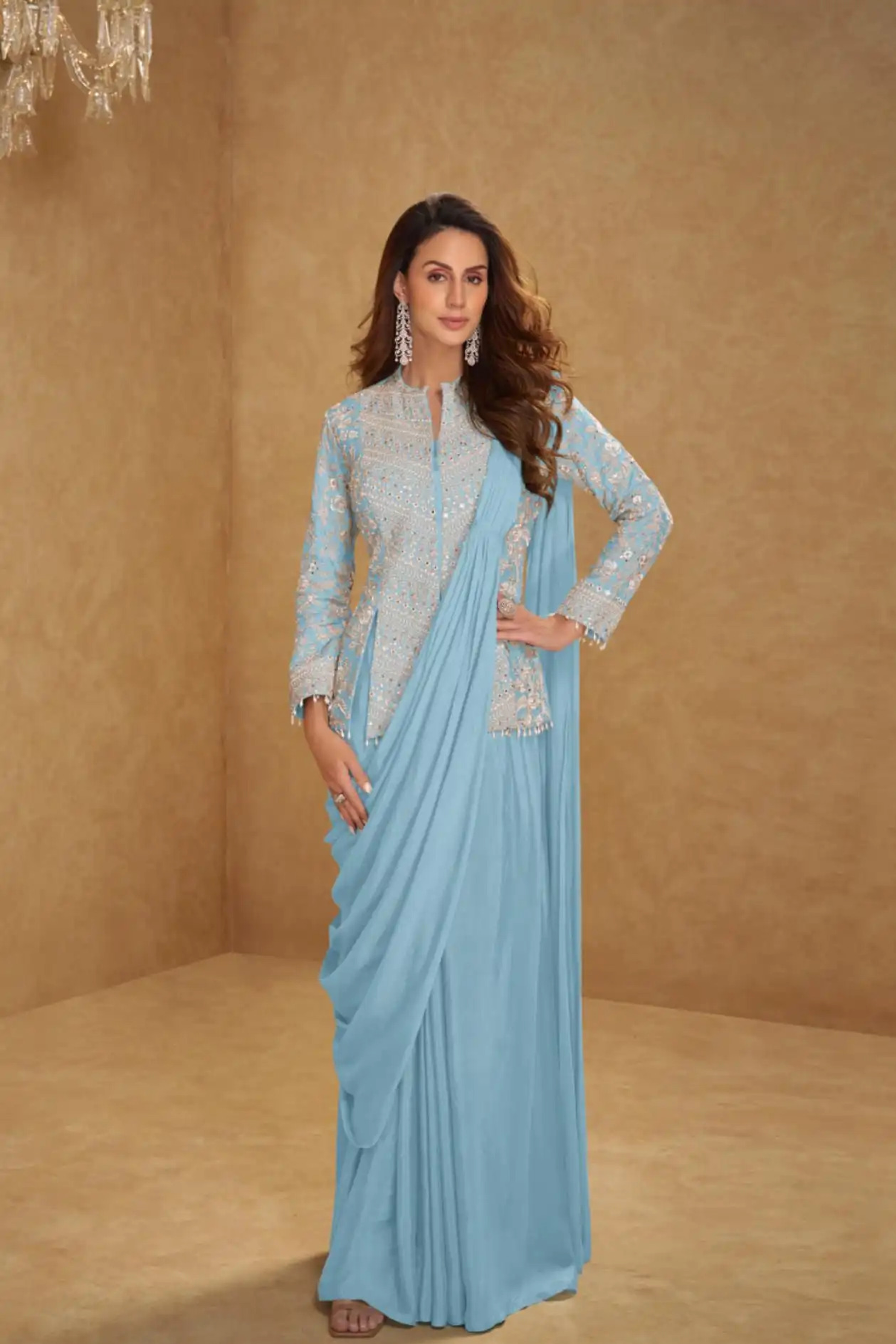 Woman wearing a light blue saree with a matching blouse against a beige background