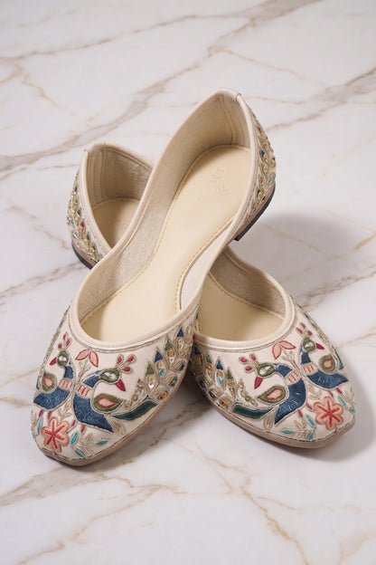 Pair of off-white juttis with detailed peacock and floral embroidery