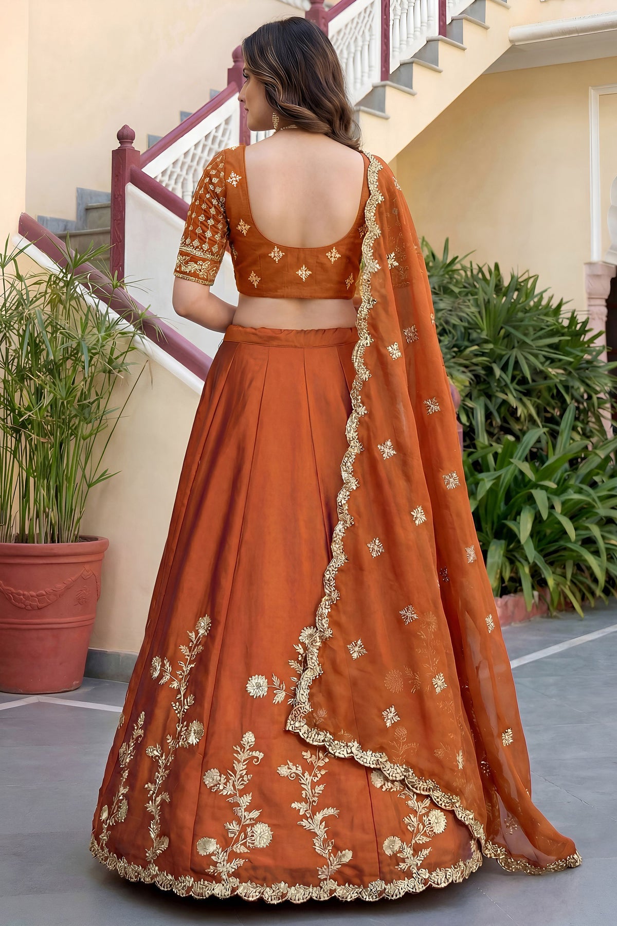 Orange lehenga choli back view showing dupatta drape
