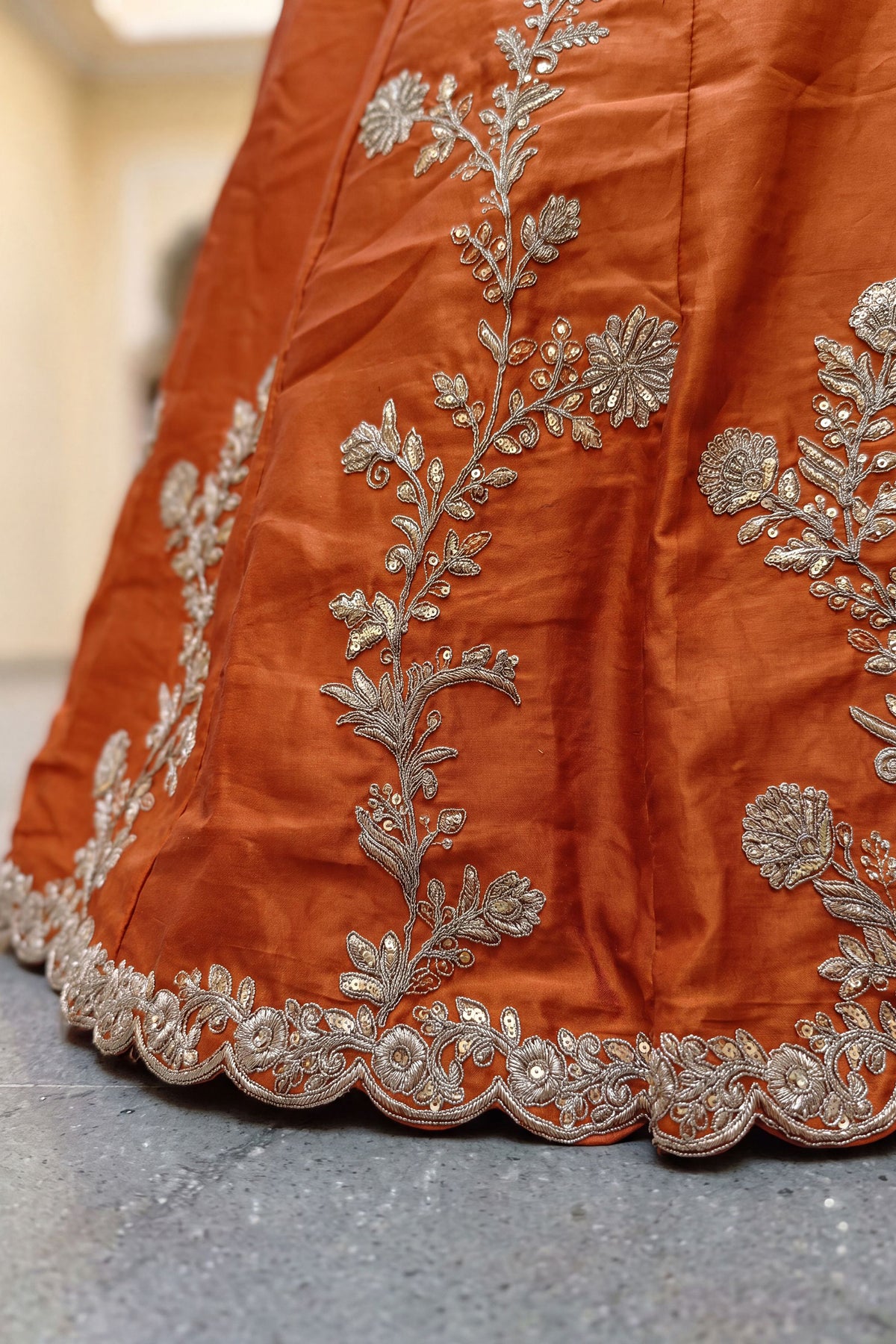 Sequence work detail on orange lehenga hem
