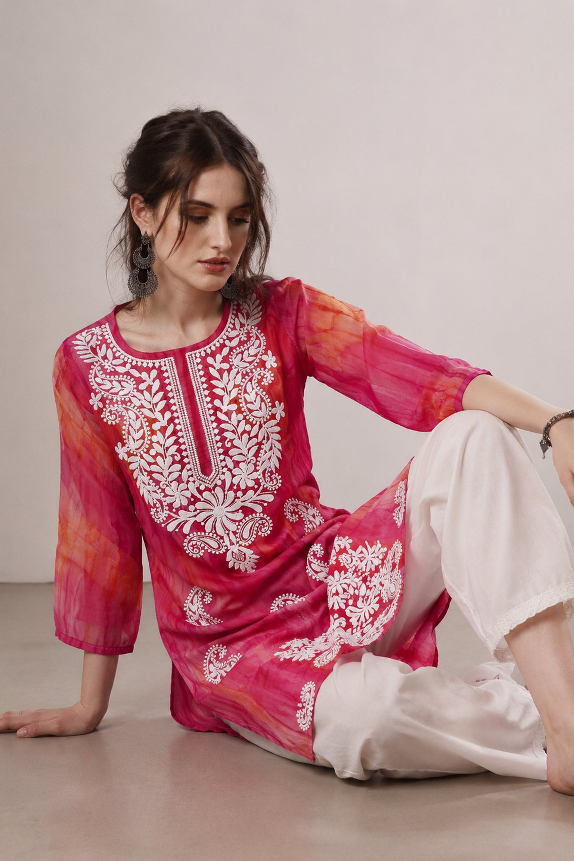 Pink Kurti paired with white pants in indoor fashion shoot