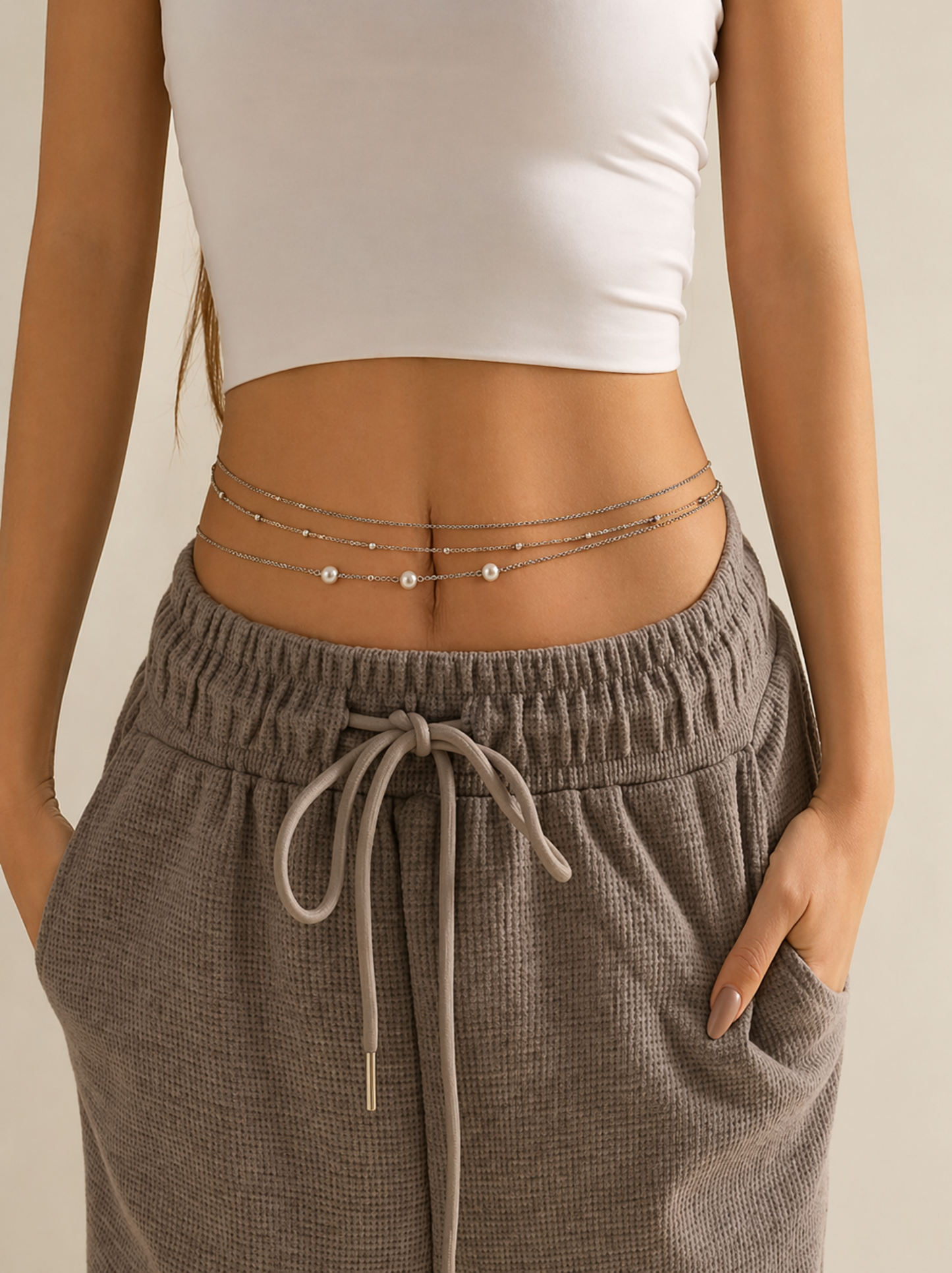 model wearing layered waist chain over pants
