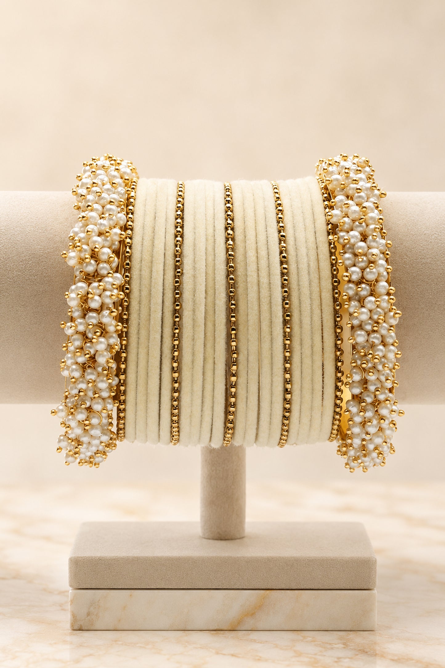 Pearl bangle set arranged in layered ivory and gold tones