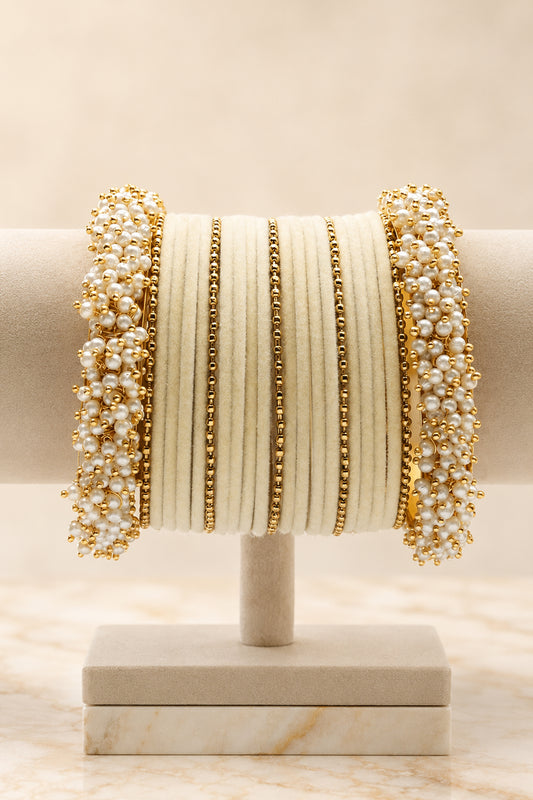 Pearl bangle set arranged in layered ivory and gold tones