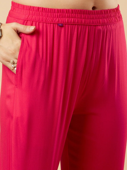 Close-up of bright pink pants with a visible brand logo.