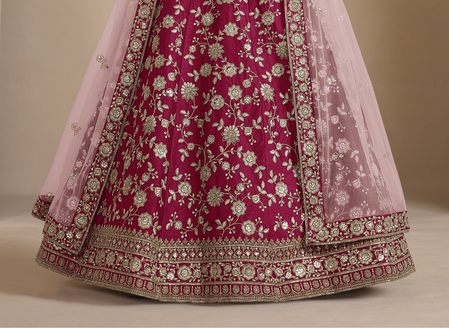Close up of embroidery work on pink silk lehenga
