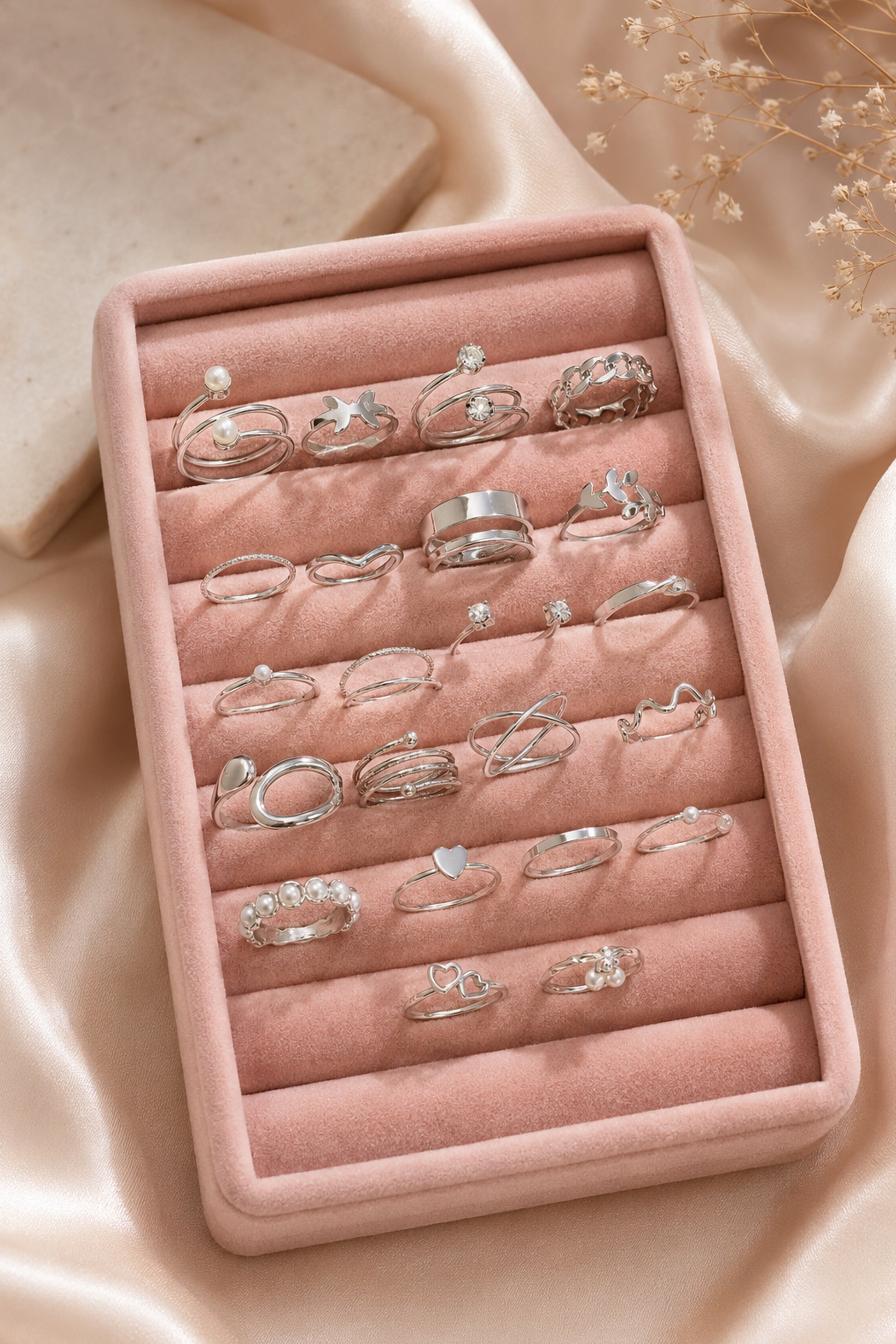 Silver-tone ring set arranged on a neutral stone surface