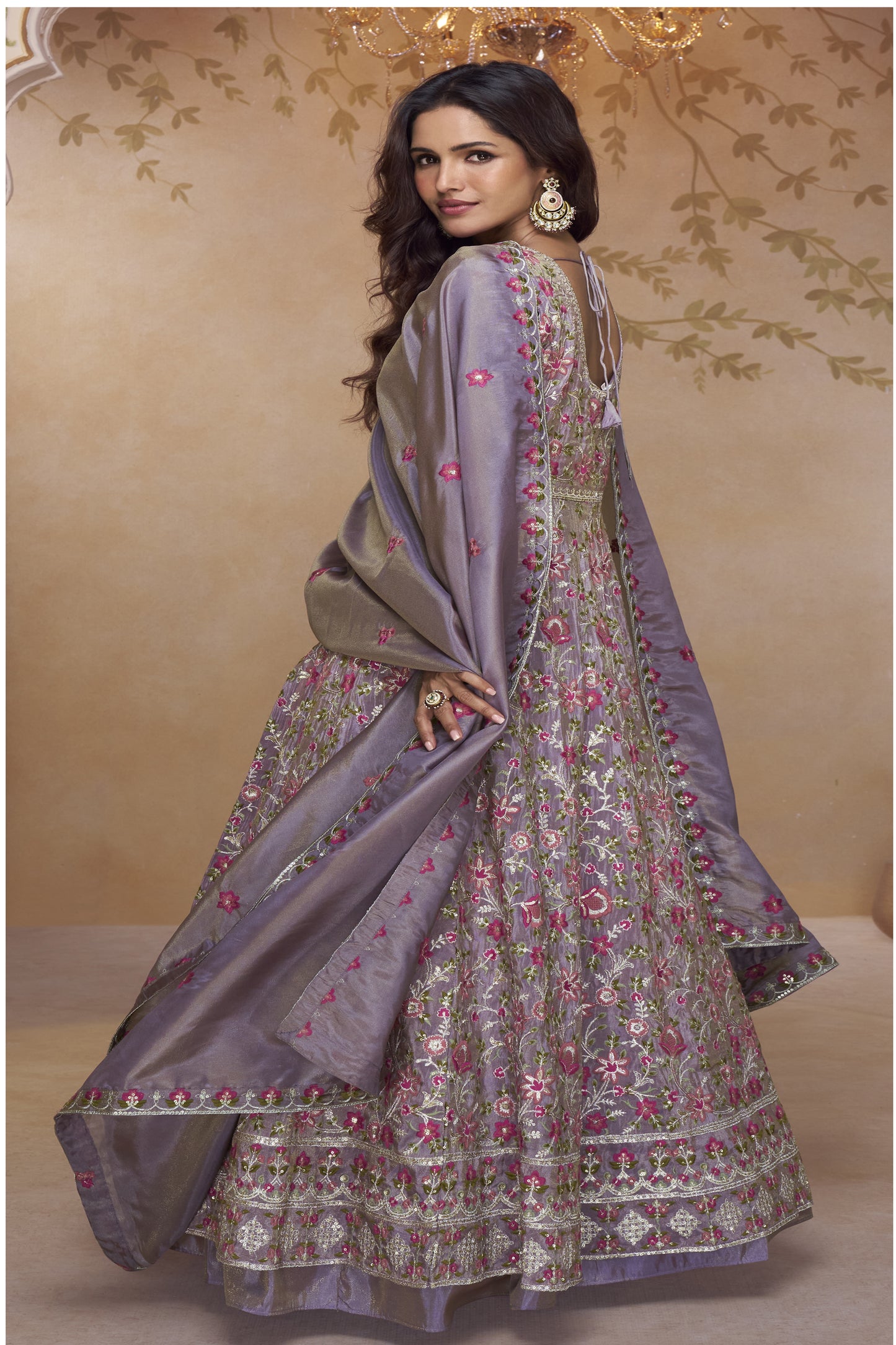 Woman Wearing a Lavender Purple Embroidered Floor-Length Gown with Floral Detailing and Matching Dupatta in a Royal Backdrop