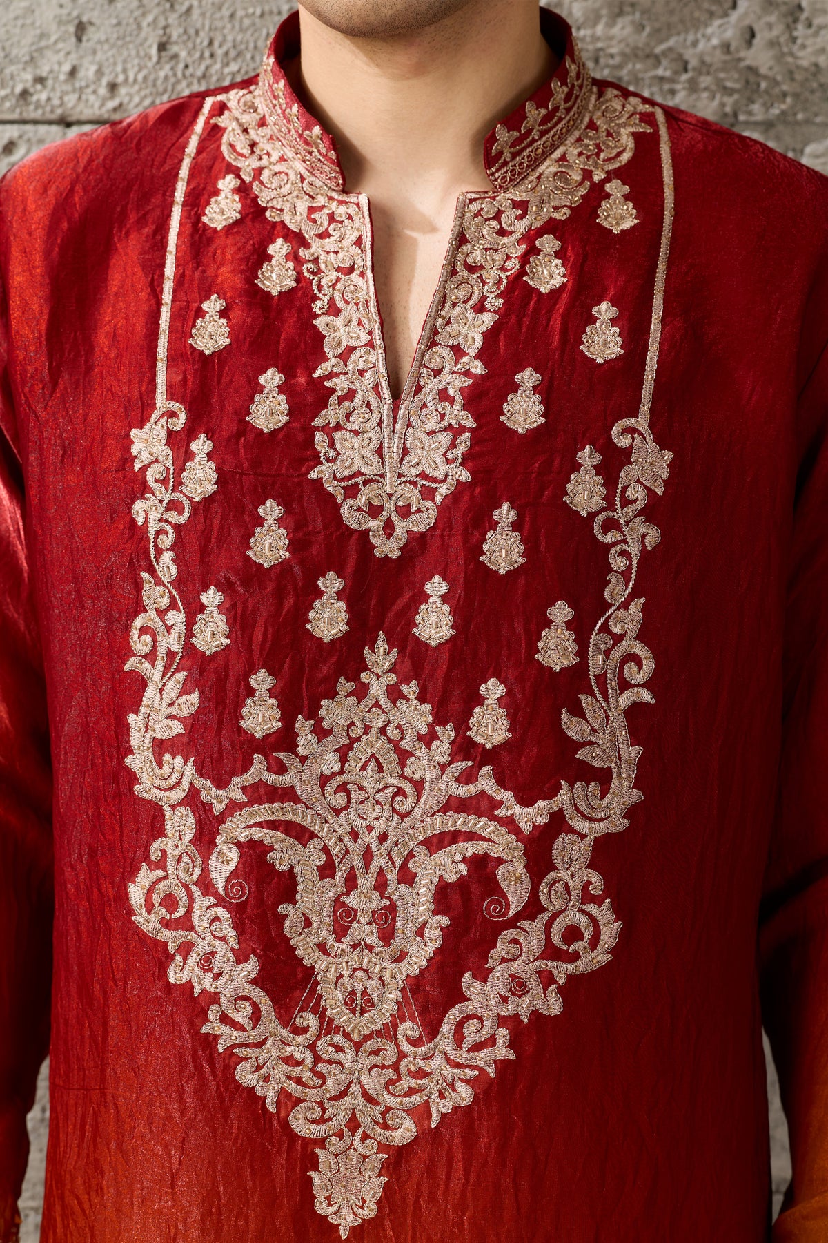 Close-up of thread and sequin embroidery on red fabric