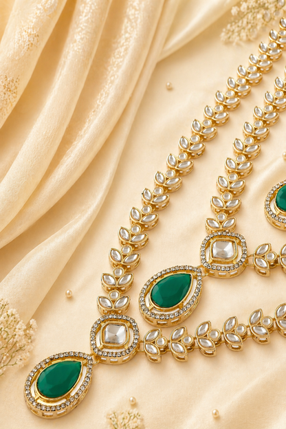 Close-up of layered leaf-link necklace with green accents