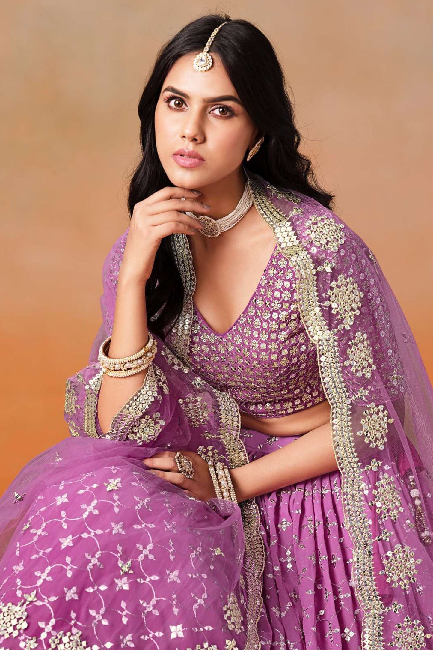 Close-up of sequins zari embroidery work on purple lehenga