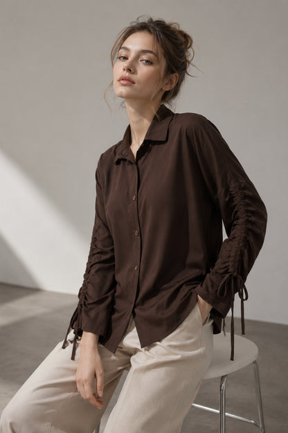 Women’s button down shirt in brown cotton shown seated