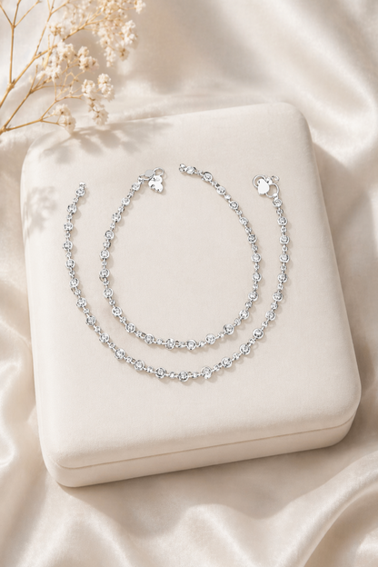 silver anklet with round clear stones on marble surface