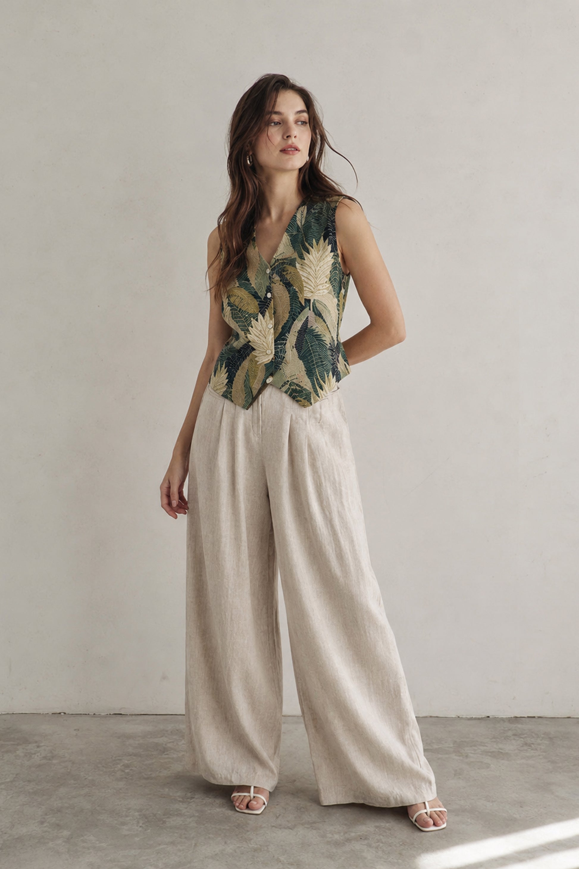 Sleeveless vest top women styled with wide leg trousers in studio setting