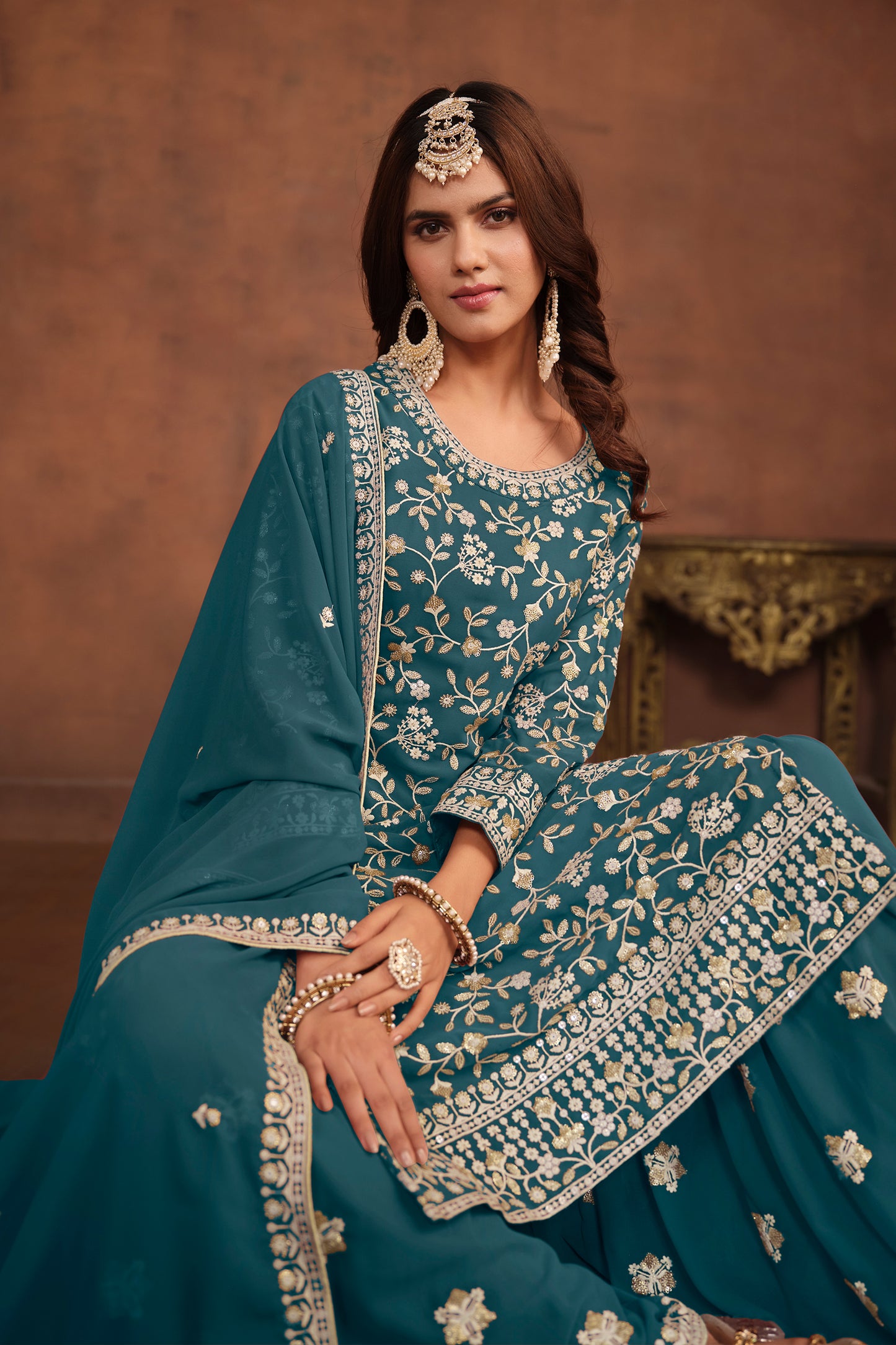 Detail of dupatta draped over shoulder in teal blue fabric