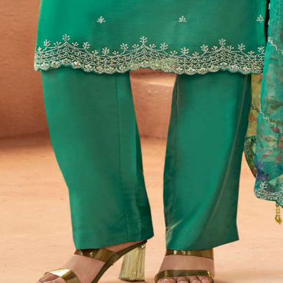 Close-up embroidery detail on teal salwar kameez fabric