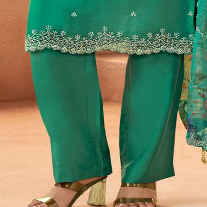 Close-up embroidery detail on teal salwar kameez fabric