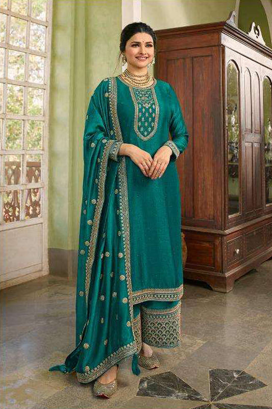 A Woman Standing Traditional Indian Setting, Wearing a Green Embroidered Palazzo Suit