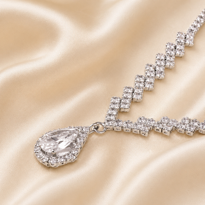 Clear stone teardrop necklace set on satin fabric